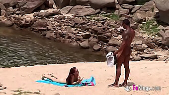 Ein Gut Bestückter Schwarzer Zieht Eine Atemberaubende Brünette Am Fkk-Strand An